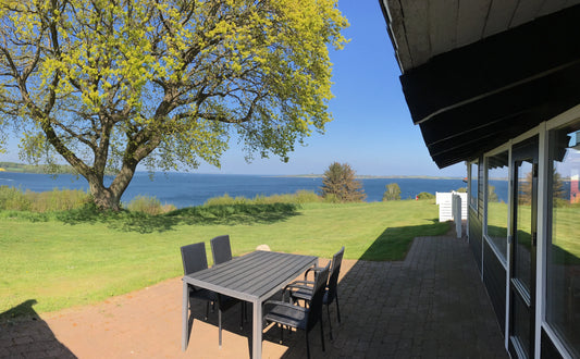 Heller Wohn-/Essbereich im skandinavischen Stil mit bodentiefen Fenstern; familienfreundliches Ferienhaus an der Ostsee, Südjütland.