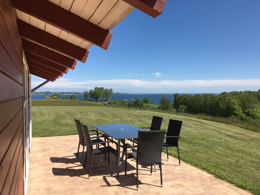 Heller Wohn-/Essbereich im skandinavischen Stil mit großer Fensterfront; familienfreundliches Ferienhaus, Ostseeküste Dänemark.