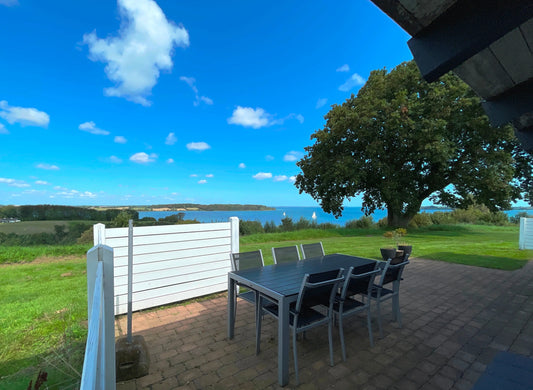 Panorama-Terrasse mit Esstisch und freiem Blick über die Ostsee/Genner Bucht in Löjt; ruhige Lage, Natur, Familien-Urlaub in Dänemark.
