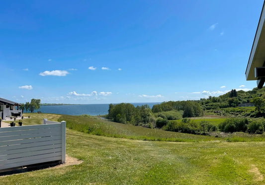 Heller Wohn-/Essbereich im skandinavischen Stil mit bodentiefen Fenstern; Urlaub an der Ostsee in Dänemark, Südjütland.