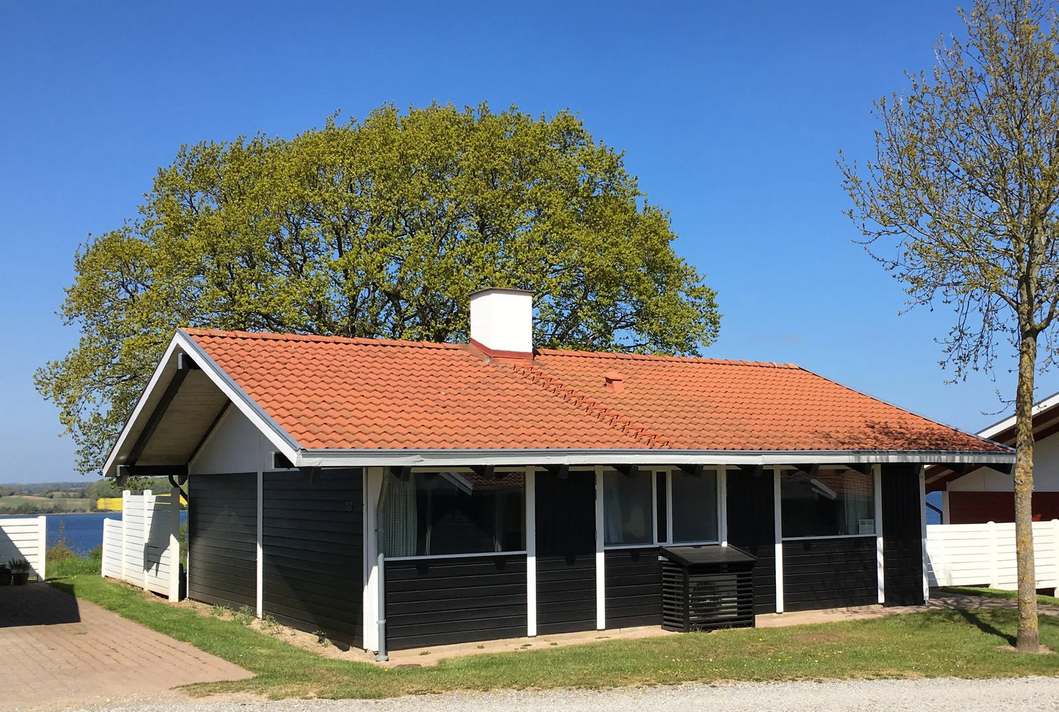 Modernes Ferienhaus in Dänemark, Südjütland – Holzfassade mit großer Terrasse, Garten und Ostsee-Nähe; Ferienhaus mieten Ostseeküste.
