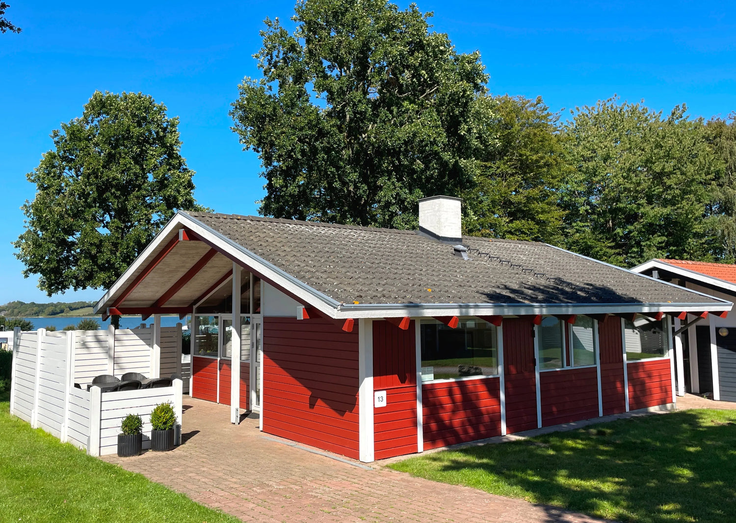 Ferienhaus in Dänemark, Südjütland – moderne Holzfassade mit großer Terrasse, Garten und Ostsee-Nähe; ideal für Familienurlaub.