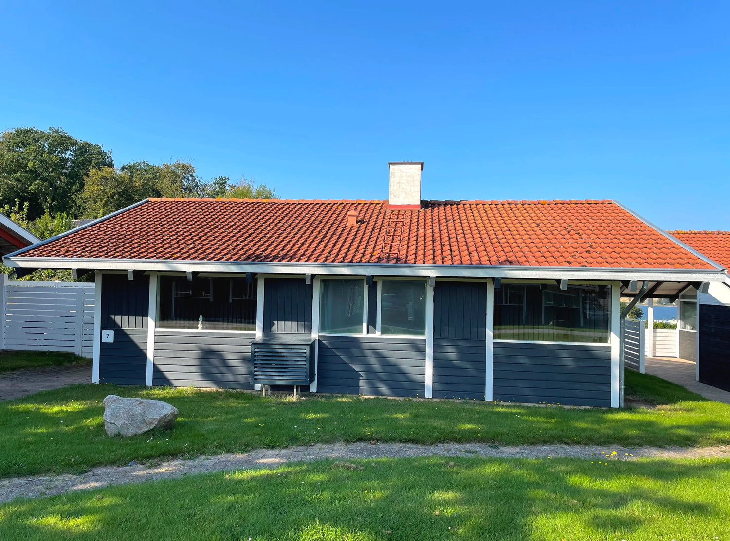 Ferienhaus in Dänemark, Südjütland – moderne Holzfassade mit Terrasse und Garten; Ostseeküste, Ferienhaus mieten, ruhige Lage.